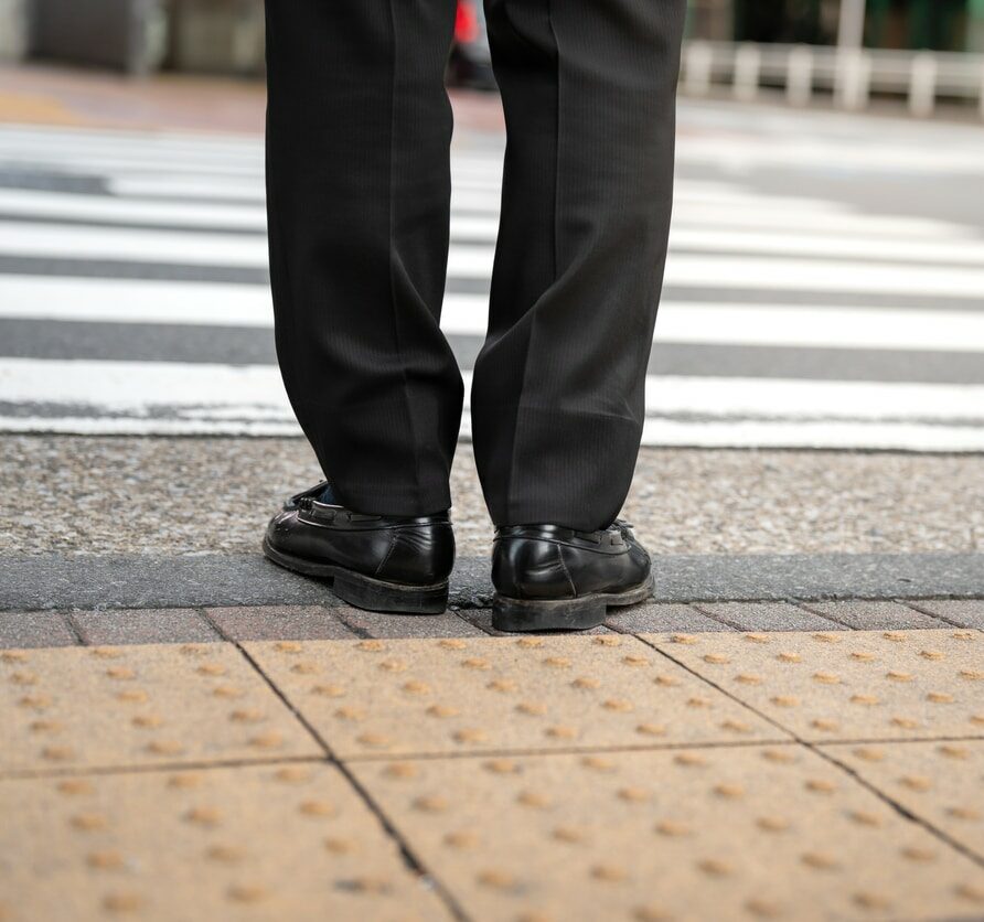 A businessman is waiting to crossing the road.